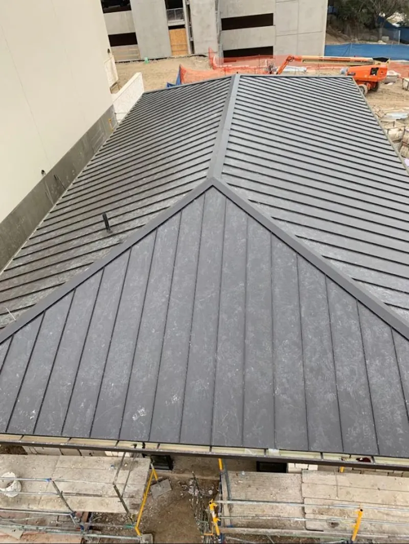 Commercial metal roof construction with crane equipment in Hillview